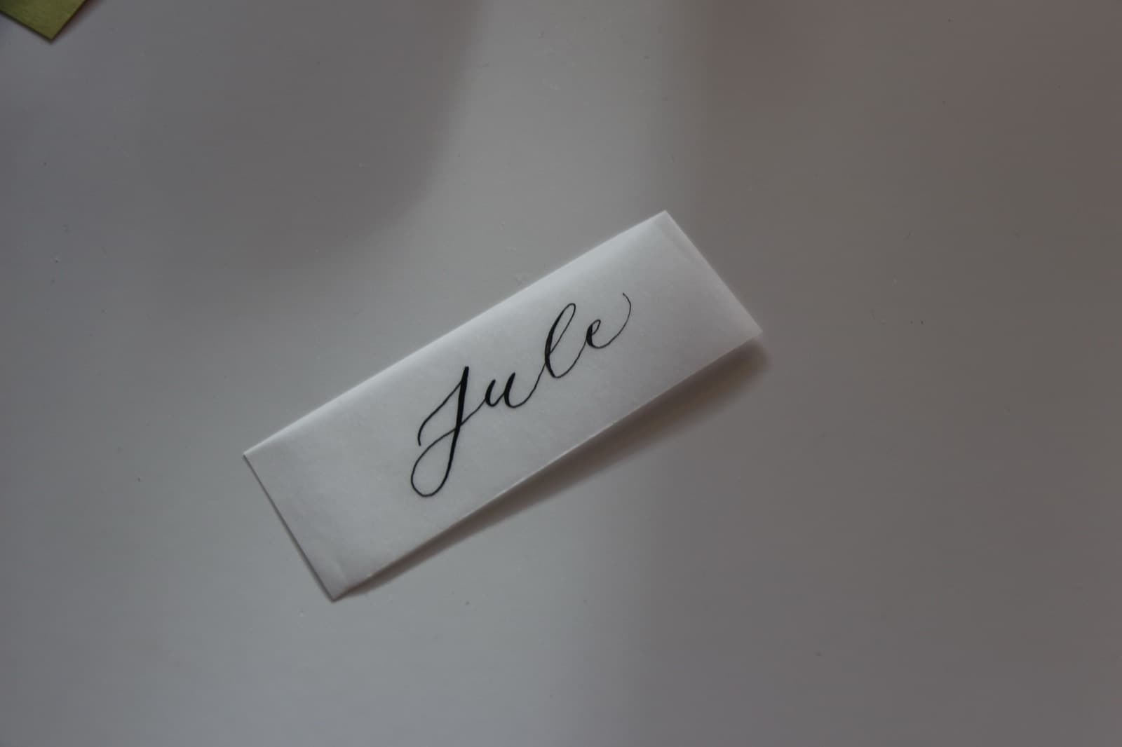 Weiße Platzkarte mit dem Namen Jule in feiner schwarzer Schreibschrift